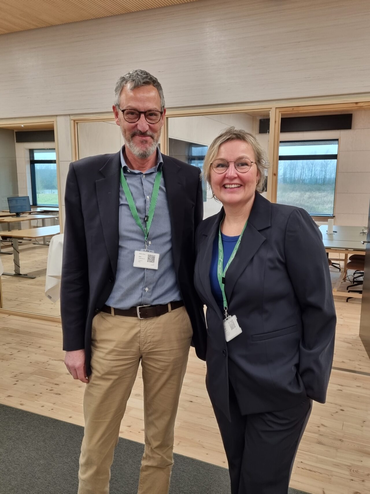 Two people standing in a conference room
