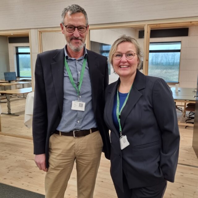 Two people standing in a conference room