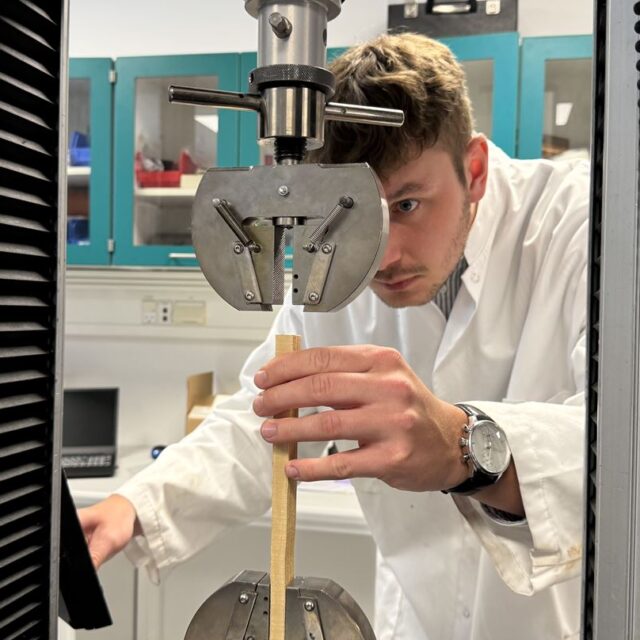 person in white lab coat in a laboratory wooden board
