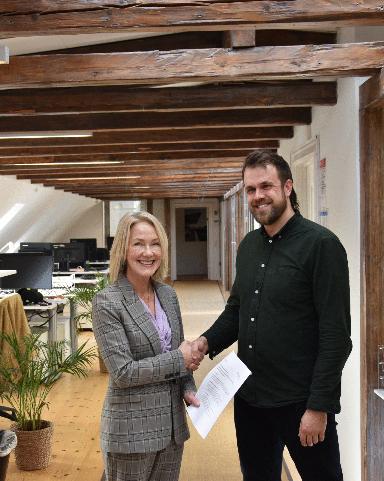 Two people shaking hands and smiling