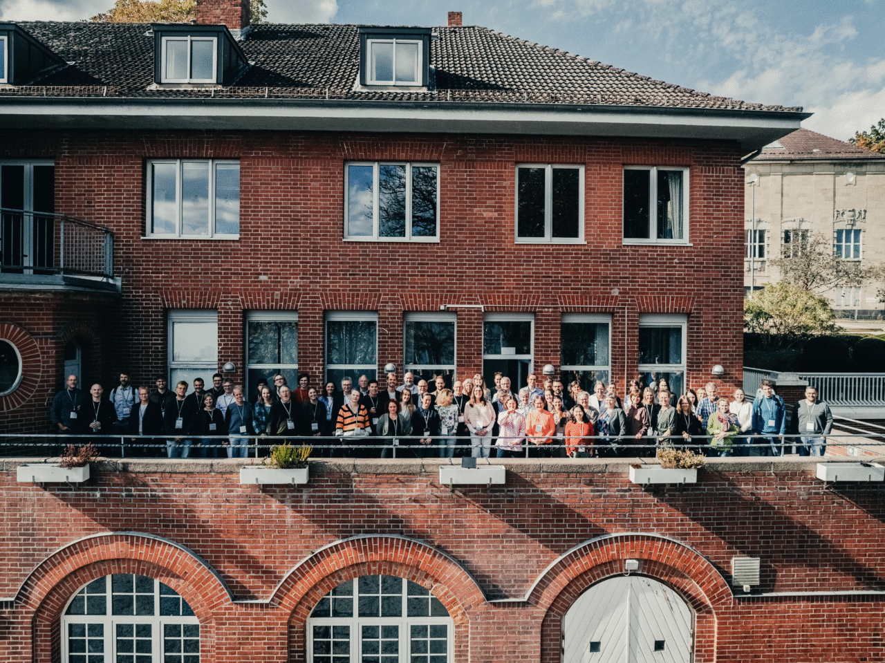 Alle deltagerne fra POSEIDONs midtvejskonference, der står samlet på en terrasse